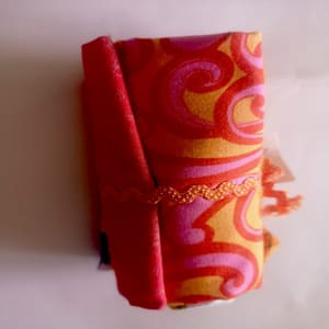 Rollito de telas en naranjas con motivos variados