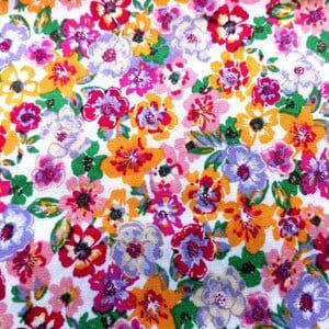 Tela de  viscosa con flores multicolores sobre blanco