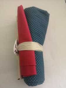 Rollito de telas con telas variadas en rojo, azul y crudo