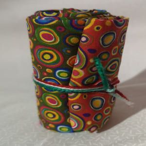 Rollito de telas de círculos de colores en verde y rojo