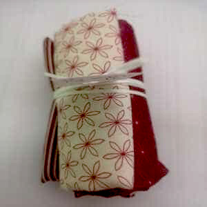 Rollito de telas  con motivos geometricos en granates