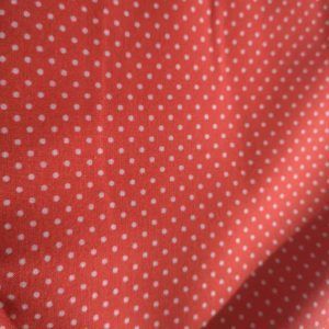 Tela con lunares sobre un rojo anaranjado ( ancho 1,50)
