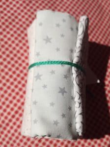 Rollito de telas  en blanco con estrellas,  lunares, copos de nieves y  motivos geométricos en plata