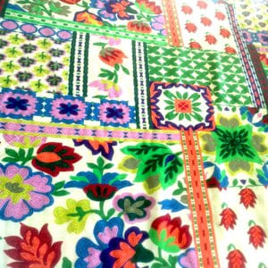Tela de viscosa con motivos variados en verdes y otros colores sobre claro